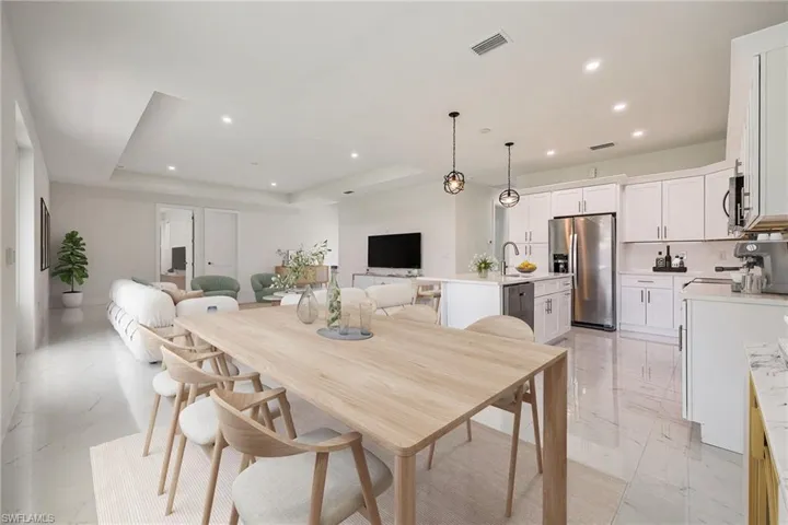 Dining area with recessed lighting, marble finish floor, visible vents, and a tray ceiling