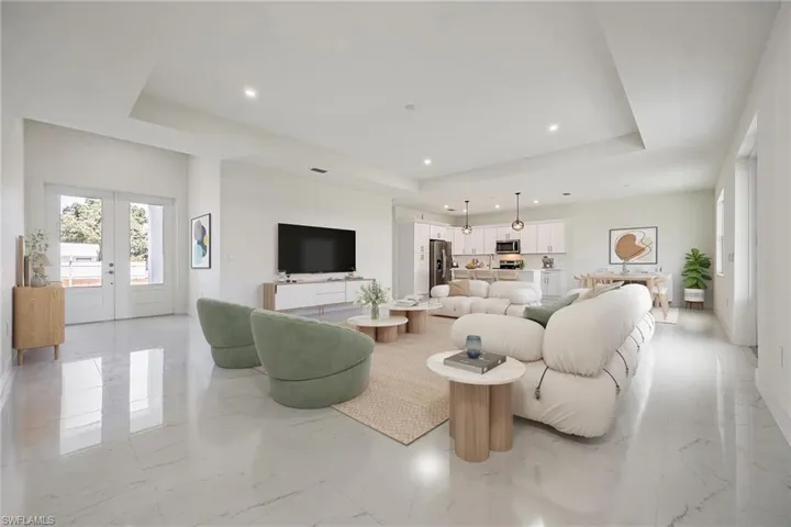 Living room with recessed lighting, marble finish floor, and a tray ceiling