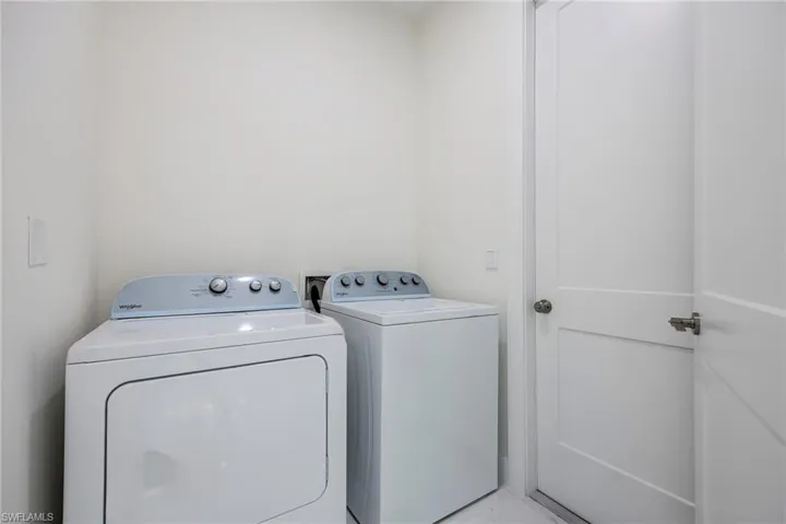 Washroom featuring independent washer and dryer and laundry area