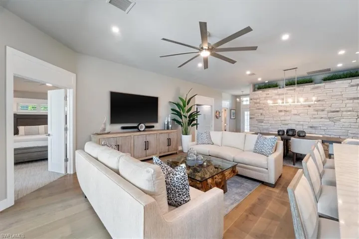 Living area with ceiling fan, light wood-style flooring, and recessed lighting
