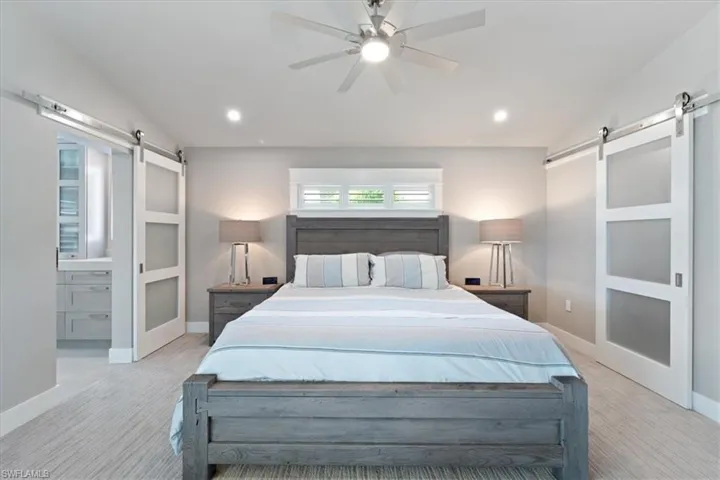 Bedroom featuring a barn door, recessed lighting, and ceiling fan