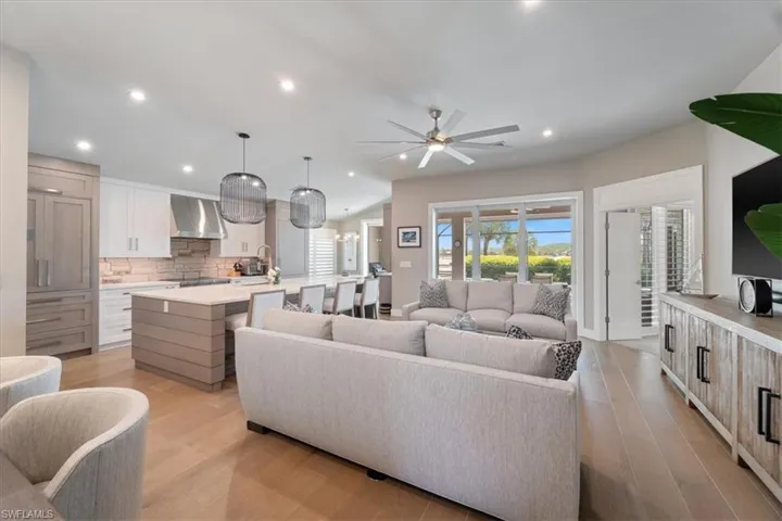 Living area with light wood finished floors, ceiling fan, and recessed lighting