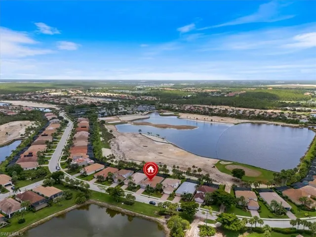 Aerial view of property and surrounding area featuring a large body of water and nearby suburban area