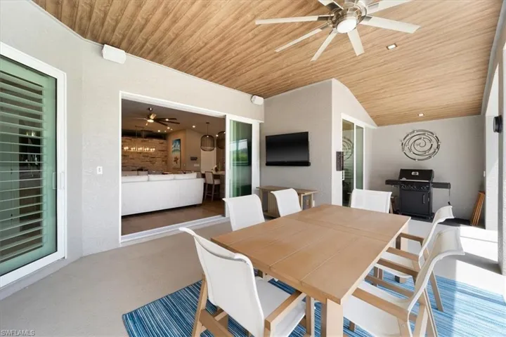 Carpeted dining space featuring ceiling fan, wooden ceiling, and lofted ceiling