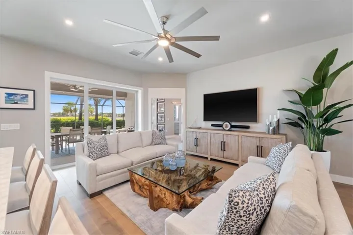 Living area with ceiling fan, light wood-style flooring, and recessed lighting