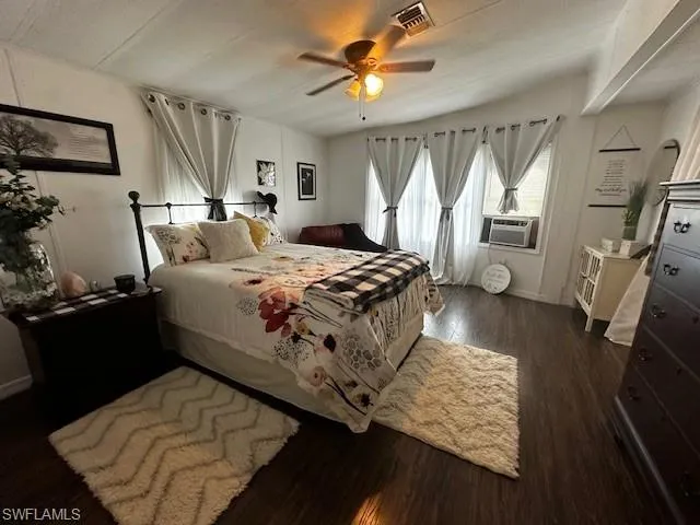 Bedroom with ceiling fan and dark hardwood / wood-style flooring