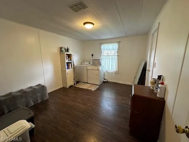 Laundry area with separate washer and dryer and dark hardwood / wood-style flooring