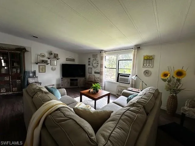 Living room with vaulted ceiling and dark hardwood / wood-style flooring