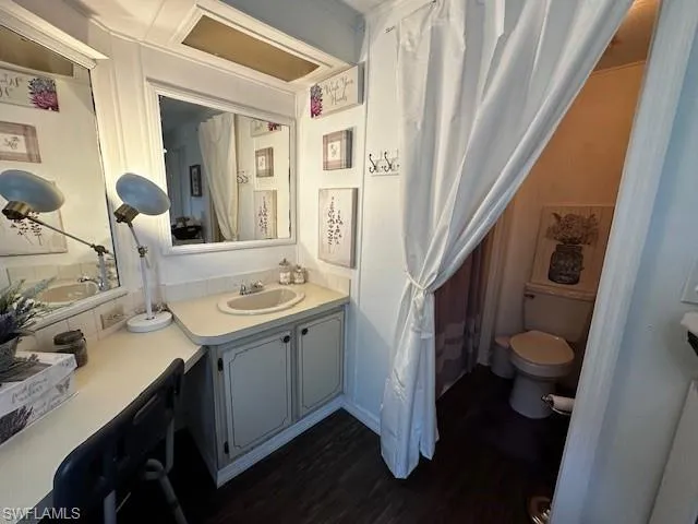 Bathroom featuring oversized vanity, hardwood / wood-style flooring, and toilet