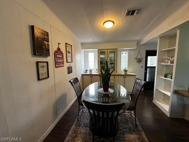 Dining space with dark hardwood / wood-style flooring and a textured ceiling
