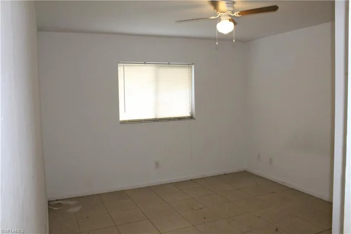 Unfurnished room featuring ceiling fan and tile patterned floors