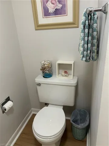 Half Bathroom with toilet and wood finished floors