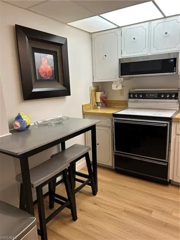 Kitchen featuring stove, light countertops, and light wood-style flooring