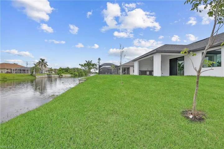 View of grassy yard with a patio area and a water view