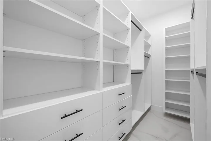 Walk in closet featuring light marble finish floors