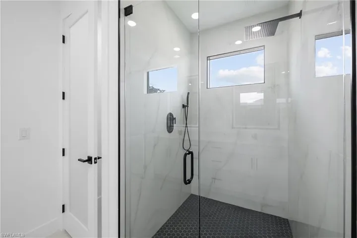 Full bath featuring a marble finish shower and recessed lighting