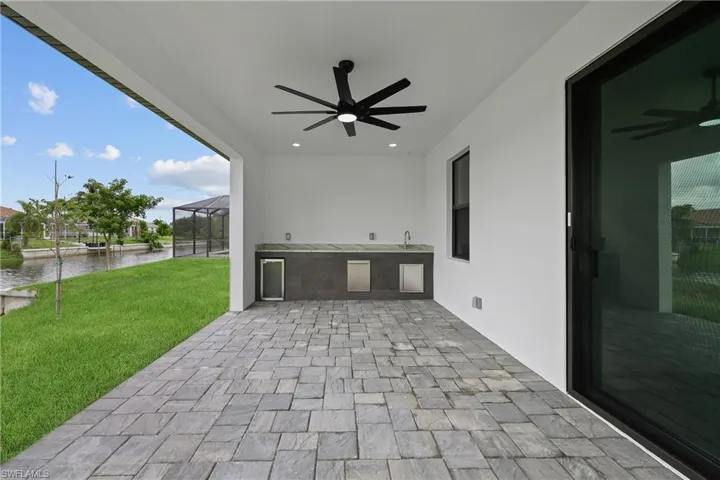 View of patio / terrace featuring a water view, a lanai, and ceiling fan