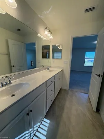 Bathroom featuring double vanity and baseboards