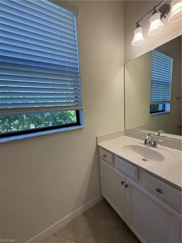 First Floor Bathroom featuring a textured wall, vanity, and dark tile patterned flooring