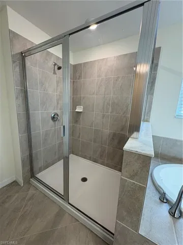 Full bath featuring a bath and a stall shower