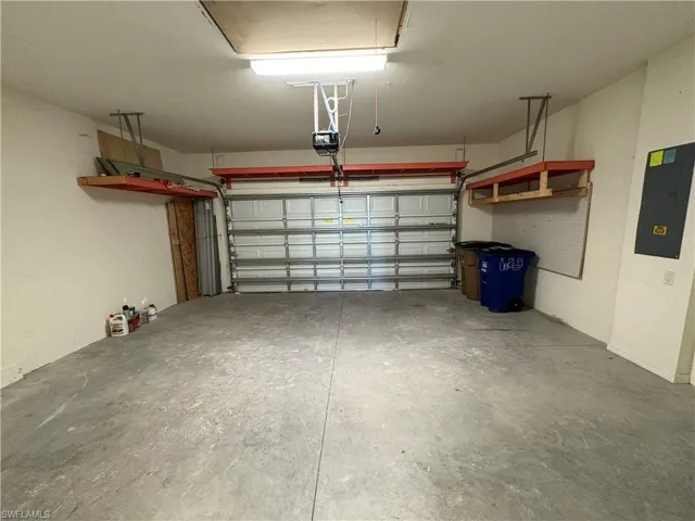 Garage with electric panel and a garage door opener