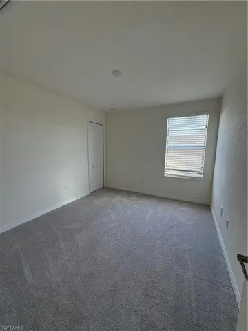 Carpeted empty room featuring baseboards