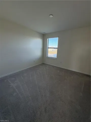 Unfurnished room with carpet flooring and baseboards