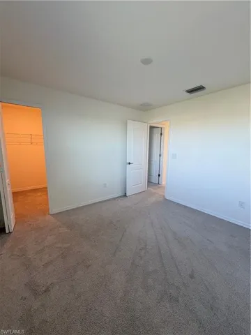 Carpeted spare room featuring baseboards