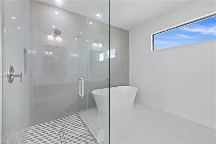 Bathroom featuring a shower stall and a freestanding tub