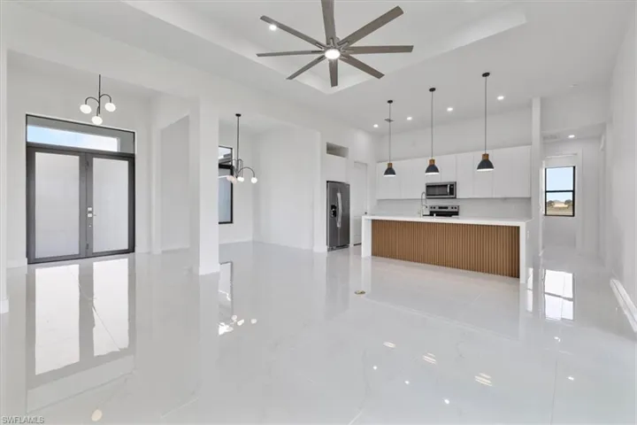 Kitchen with open floor plan, white cabinetry, decorative light fixtures, a chandelier, and recessed lighting