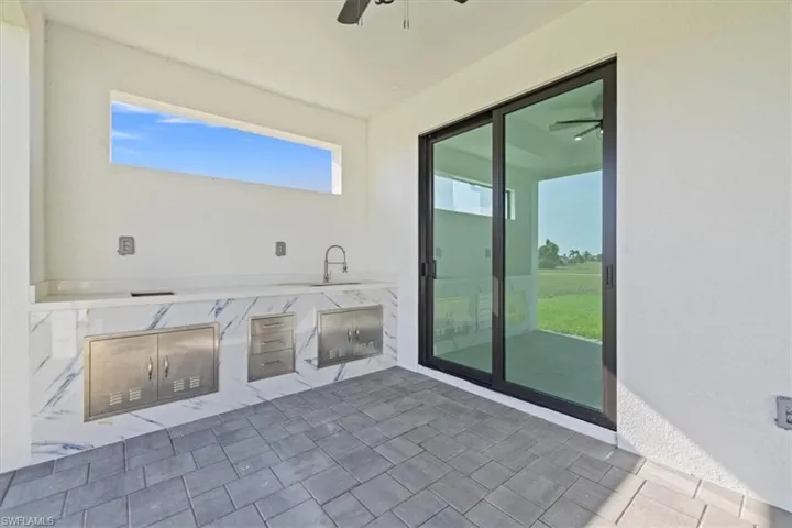 View of patio with an outdoor kitchen and a ceiling fan
