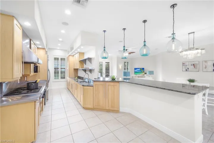 Kitchen featuring light brown cabinetry, ceiling fan, light tile patterned flooring, baseboards, and recessed lighting