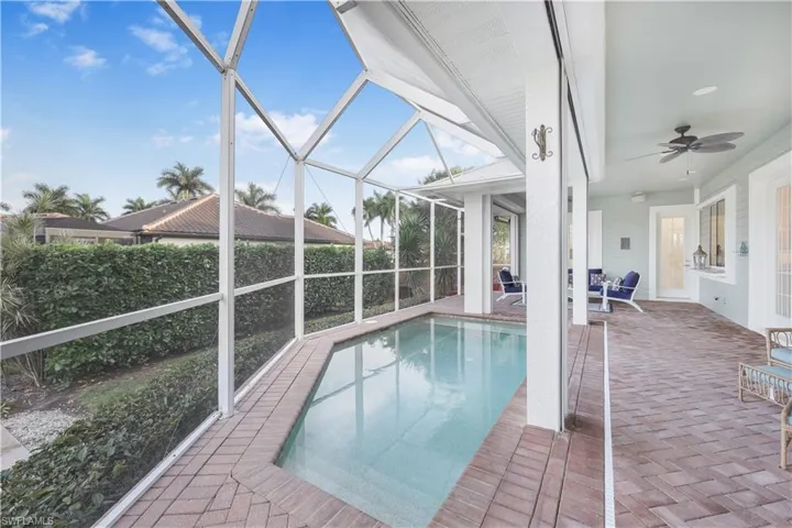 View of swimming pool with a patio area, a ceiling fan, and a lanai