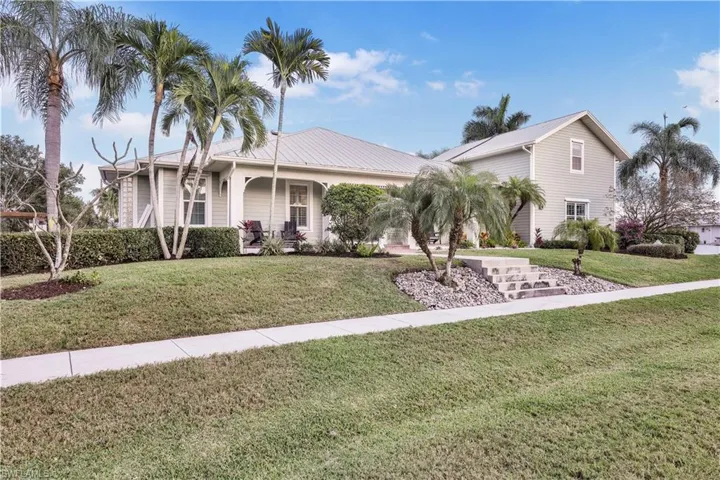Single story home featuring a front lawn and metal roof