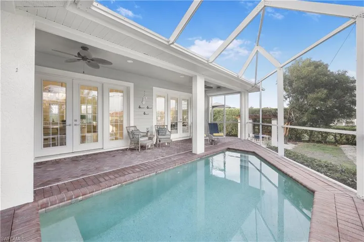 Outdoor pool with french doors, ceiling fan, a patio area, and glass enclosure