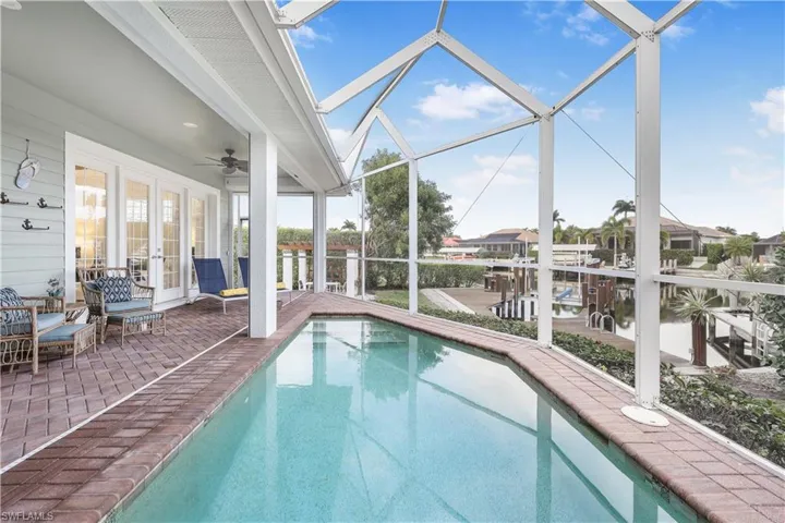 Outdoor pool with french doors, a patio, ceiling fan, and a lanai