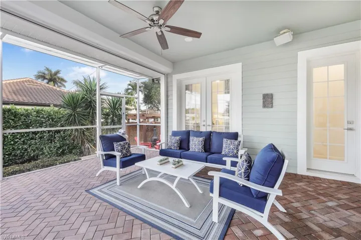Sunroom featuring a ceiling fan, an outdoor living space, and french doors
