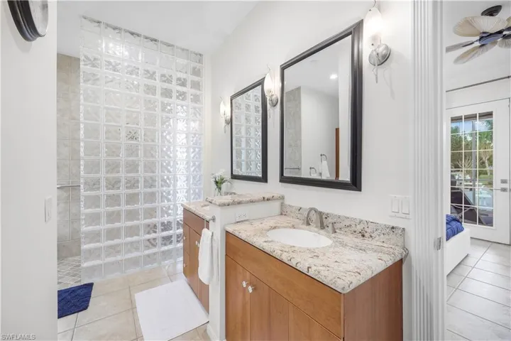 Full bath featuring tile patterned flooring, vanity, walk in shower, and ensuite bathroom