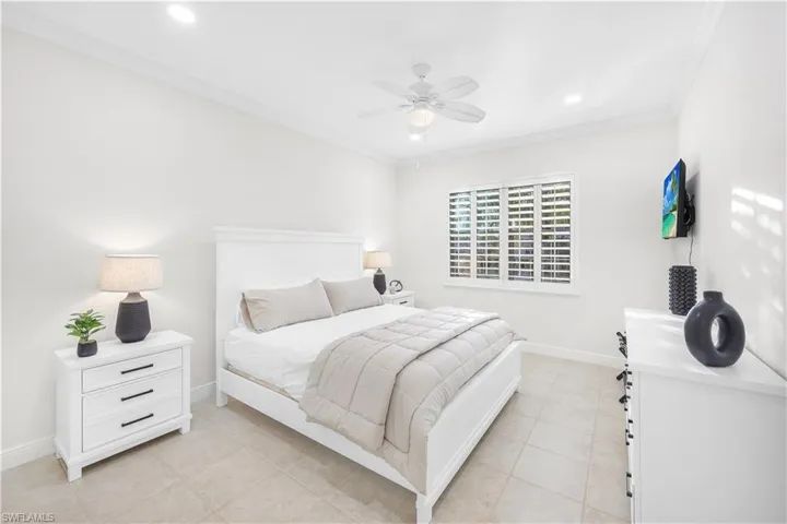 Bedroom with ornamental molding, baseboards, light tile patterned floors, recessed lighting, and ceiling fan