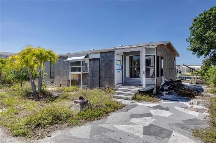 Single-story structure with a covered entry, an enclosed porch, and a patterned concrete driveway