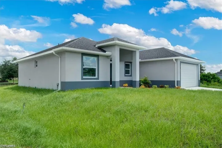 View of front facade with a garage and a front lawn