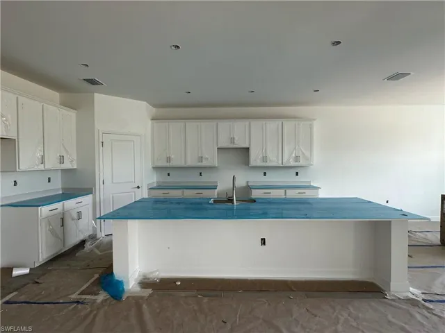 Kitchen with a center island, sink, and white cabinets