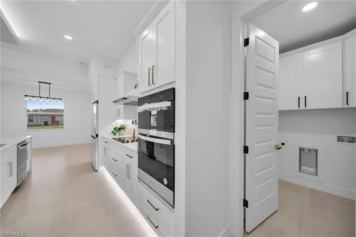 Kitchen with recessed lighting, appliances with stainless steel finishes, white cabinets, and light countertops