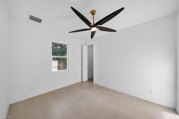 Empty room featuring visible vents, baseboards, and a ceiling fan