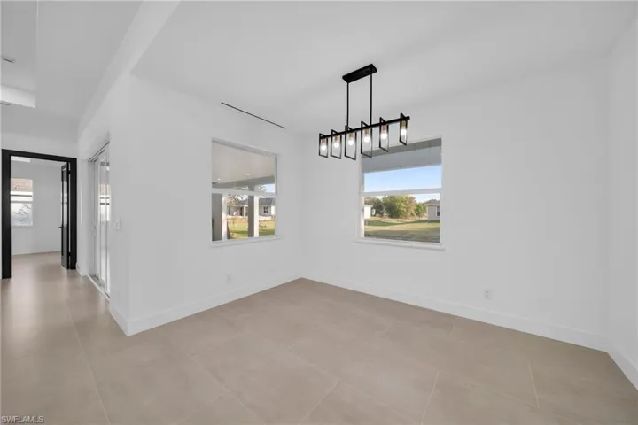 Unfurnished dining area featuring light tile patterned floors and baseboards