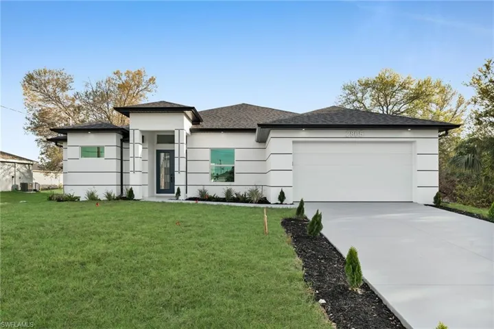 Prairie-style house featuring stucco siding, driveway, a front lawn, and a garage