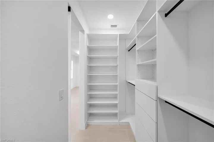 Spacious closet featuring light tile patterned flooring and visible vents