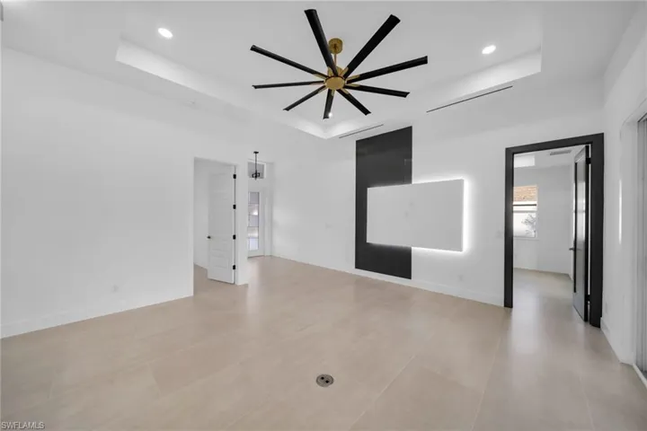 Unfurnished room featuring a tray ceiling, recessed lighting, and baseboards