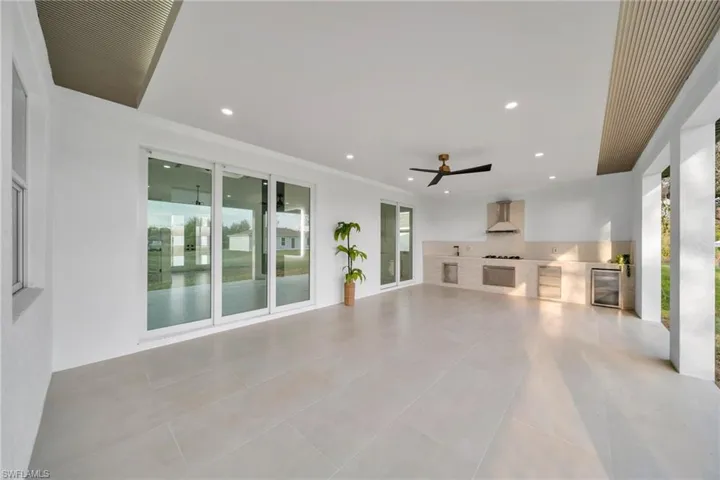 Unfurnished living room featuring wine cooler, light tile patterned flooring, recessed lighting, and ceiling fan