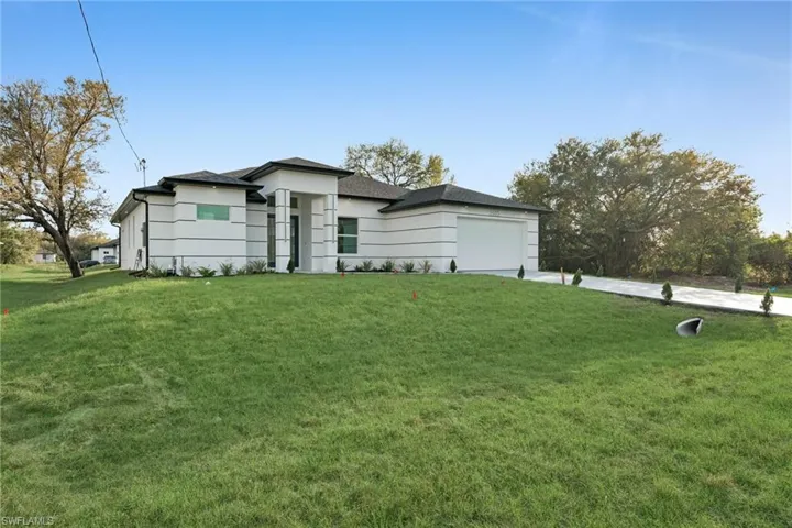 Prairie-style home with concrete driveway, a front lawn, and a garage